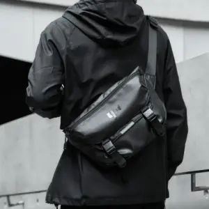 Schwarze wasserdichte Messenger-Tasche mit Schnallen, getragen über der Schulter
