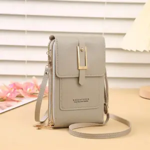 Taupefarbene Handytasche mit Klappe und goldener Schnalle auf einem Tisch