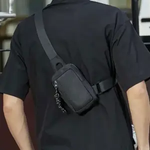 Schwarze kleine Umhängetasche, von hinten quer über den Rücken getragen